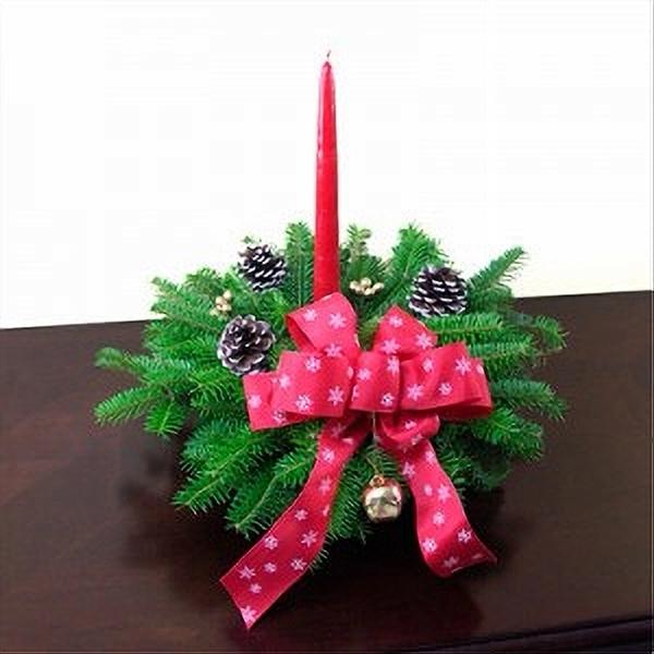 Snow Centerpiece featuring fresh Balsam greenery with frosted pine cones, gold ornaments, golden berries, and a red bow with white snowflakes, centered with a red candle for holiday table decor